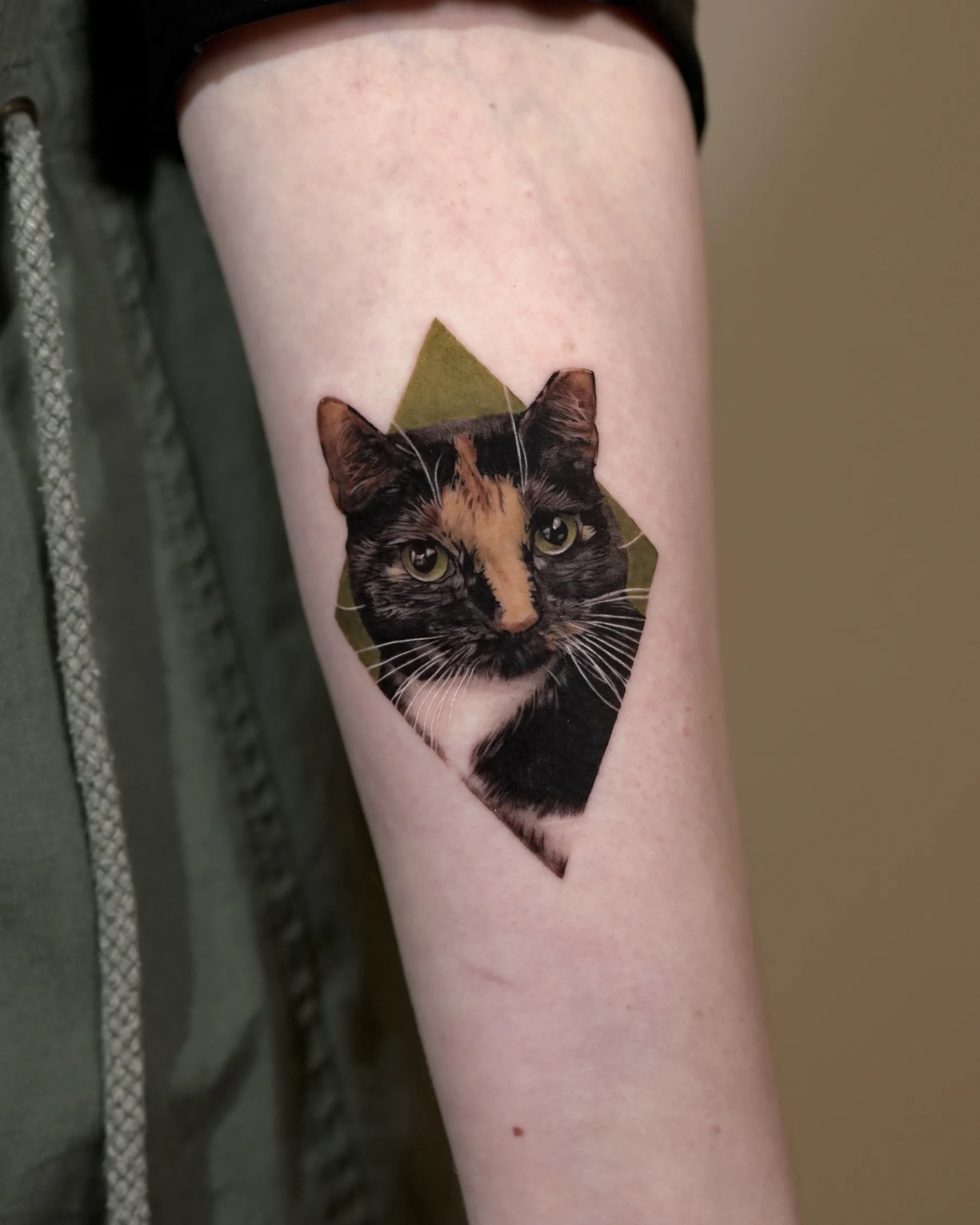 Color portrait tattoo of a tortoiseshell cat