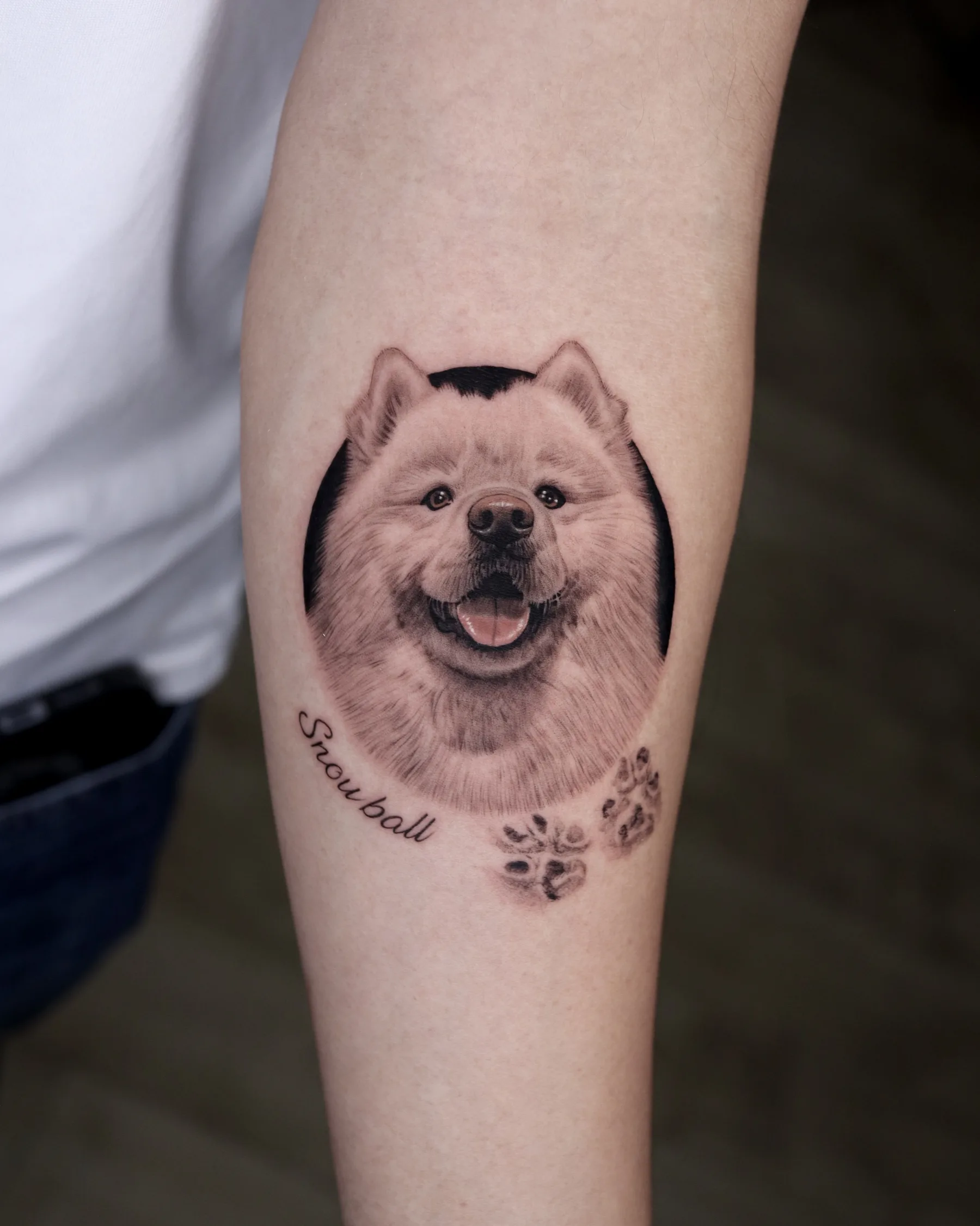 Black and grey Samoyed portrait tattoo with paw prints and name Snowball
