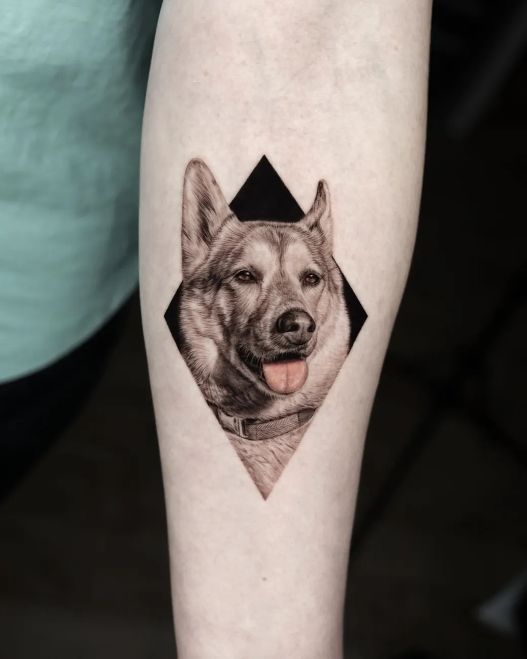 Realistic black and grey German Shepherd portrait tattoo in a diamond frame