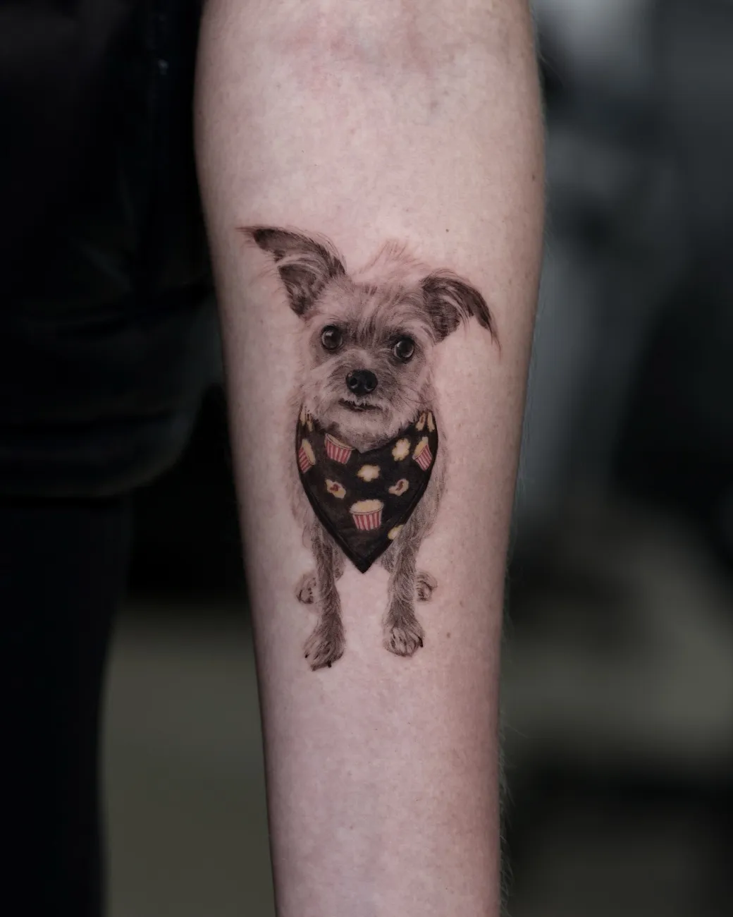 Realistic terrier portrait tattoo wearing a color bandana