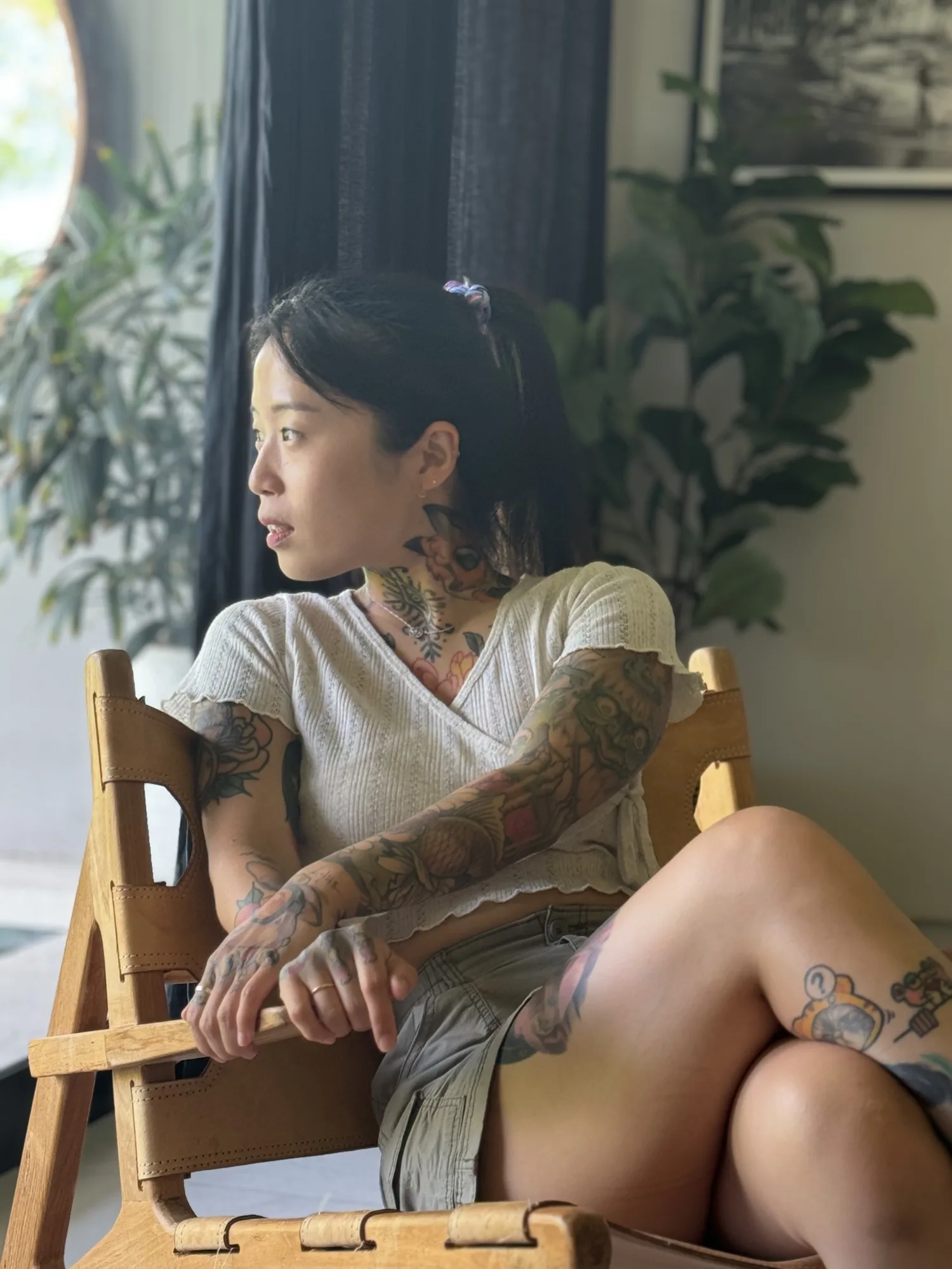 Tattoo artist Yeono seated beside a window